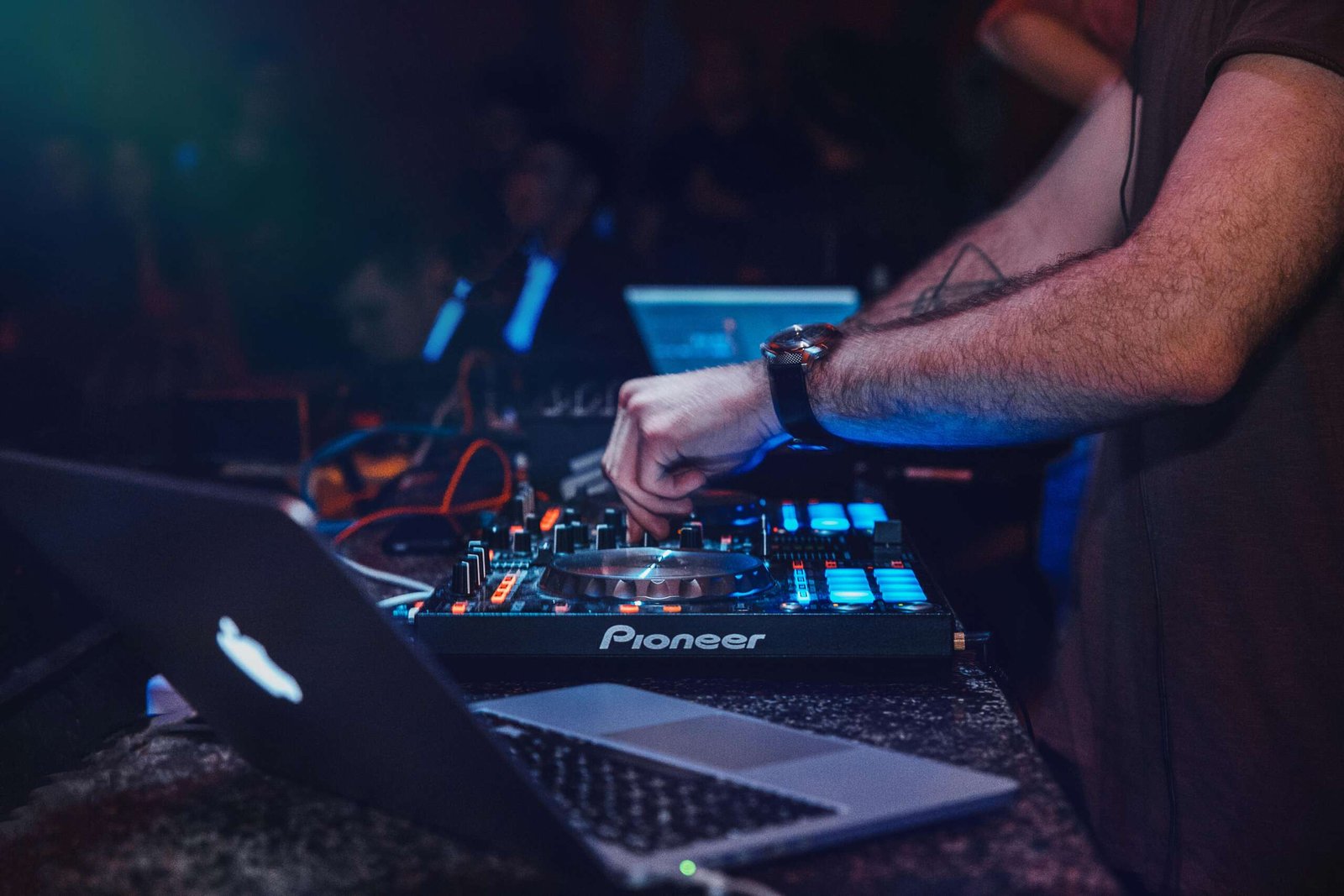 DJ performing with mixer in a vibrant nightclub setting. Perfect for entertainment and technology themes.